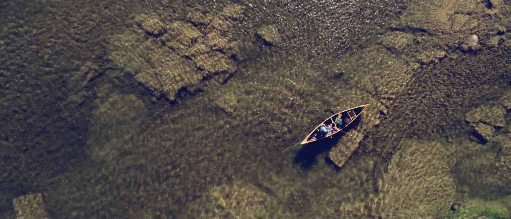 Canoe passing over rocks on a clear river