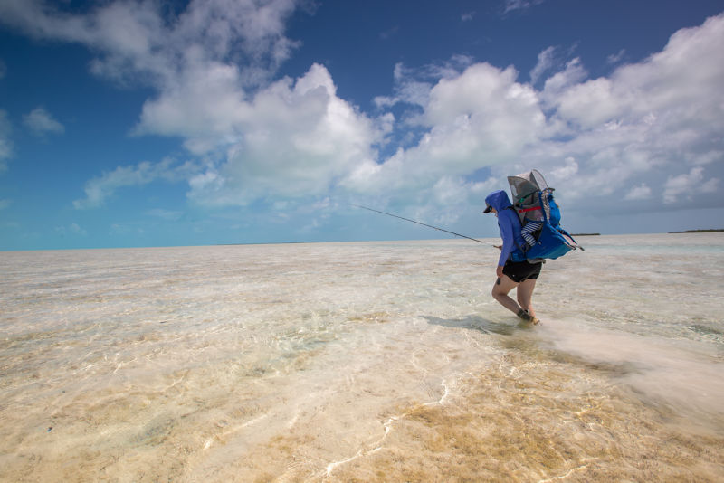 Woman and child walking through tropical water.