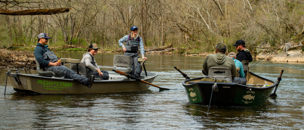 A group of anglers in two boats floating in a river