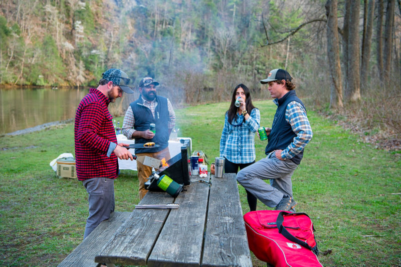 A group of friends talk around a picnic table.