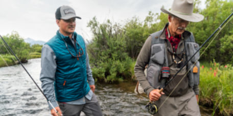 Two men with fly rods walking through a river