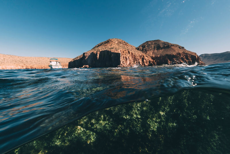 Looking at a boat and land from the perspective of tropical water.