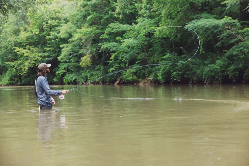 An angler draws circles in the air with his fly line.