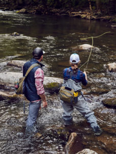 Two anglers casting into a rocky river