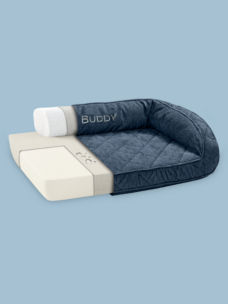 A navy Memory Foam Bolster Dog Bed on a blue background