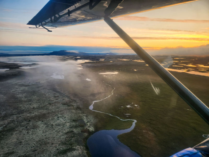 A view of the sunset from inside a small float plane.
