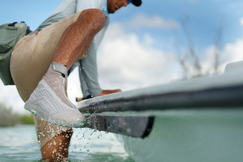 An angler in Salt PRO Approach hikers hops into his skiff.