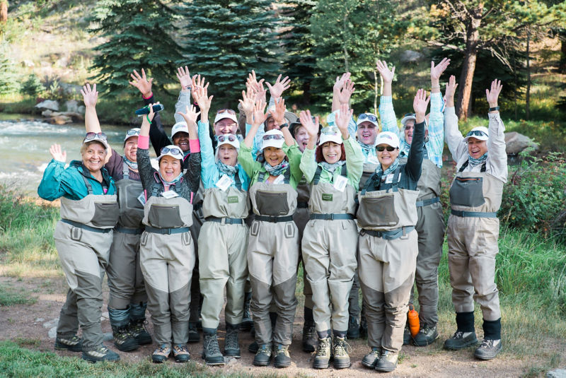 A group of anglers celebrating with their arms up.
