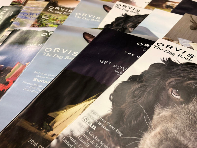 A close up of scattered Orvis catalogs.