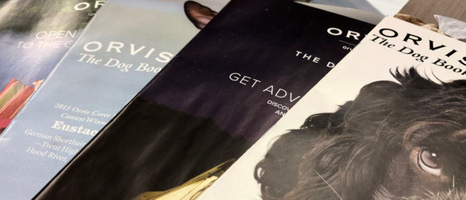 A close up of scattered Orvis catalogs.
