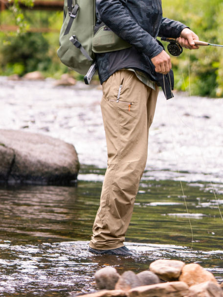 Man in fly fishing gear stands in a river