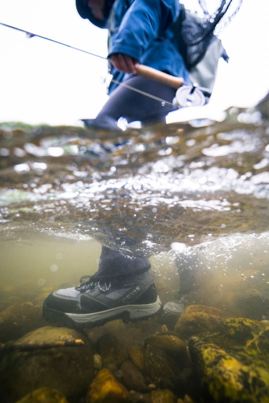An Orvis wading boot underwater.