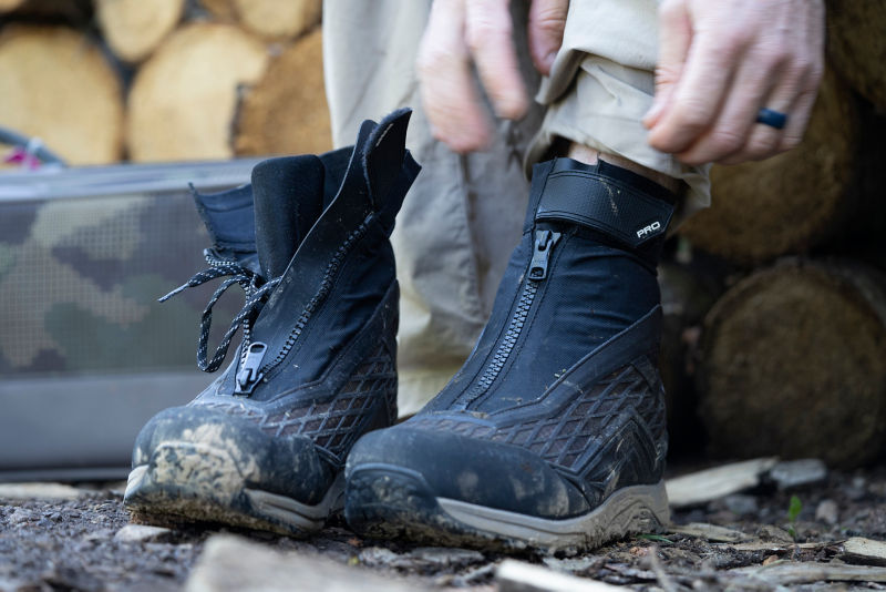 A person pulls on their Orvis wading boots.