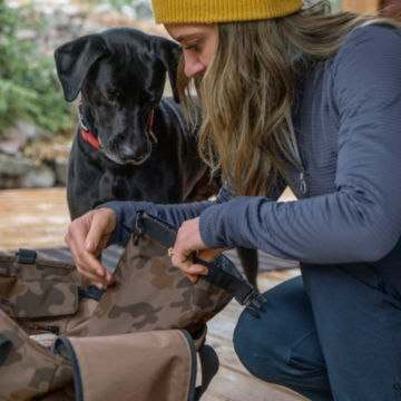 A dog and its owner look through a Tough Trail Chuckwagon Dog Tote.