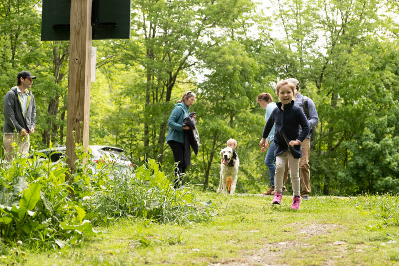 A family taking a walk with their dog.