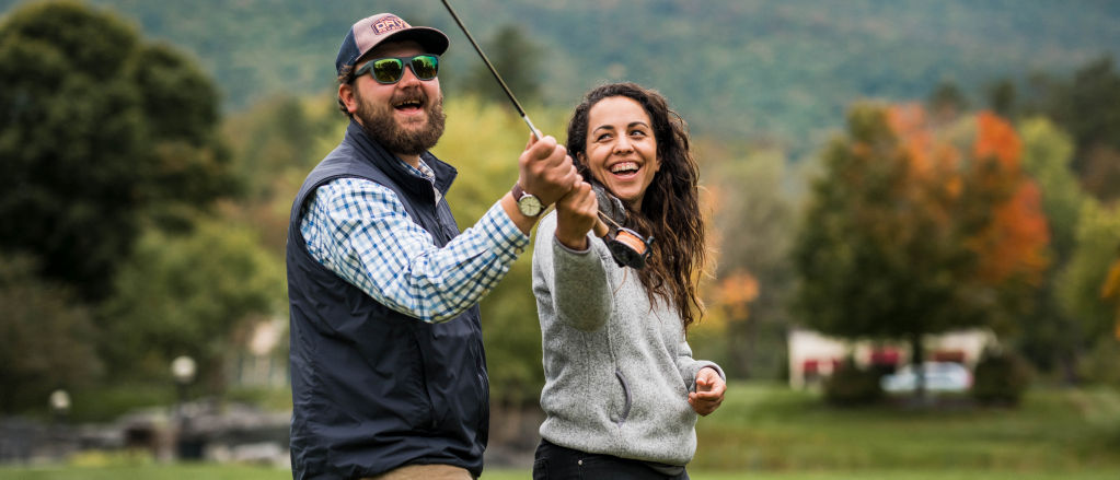 An instructor assists a student with a cast from her fly rod.