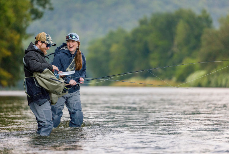 An angler pulling gear from their waterproof sling pack.