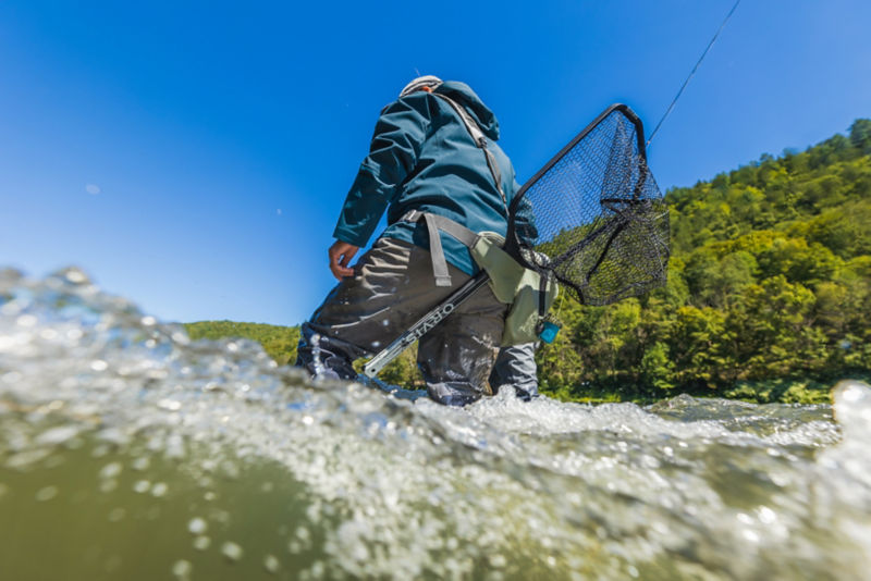 A water-level view of an angler in waders.