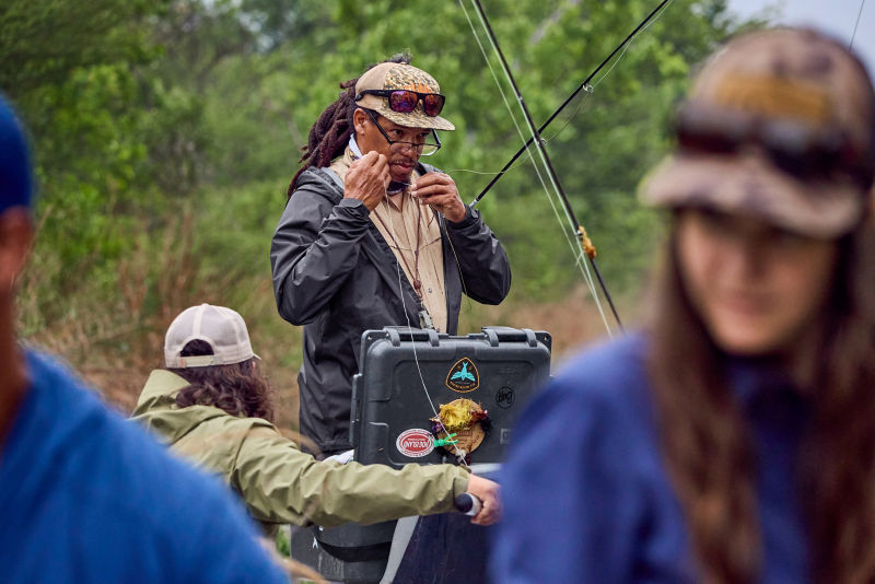 A guide stands fixing the line of a fly rod on the river. 