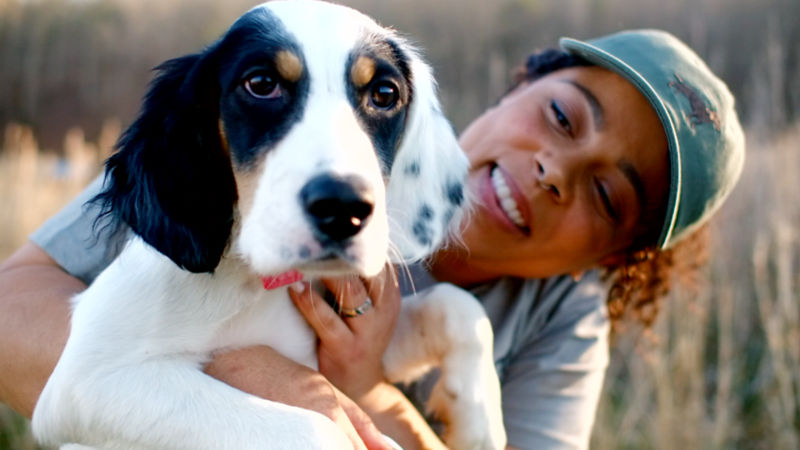 Melinda and her dog snuggling outdoors
