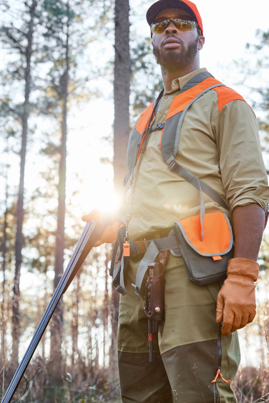 Durrell Smith looks on through the woods as he adjusts his hunting gear.