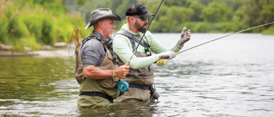 Orvis guide teaching a man how to fish