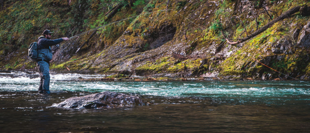 An angler lets his fly line drift in shallow water.