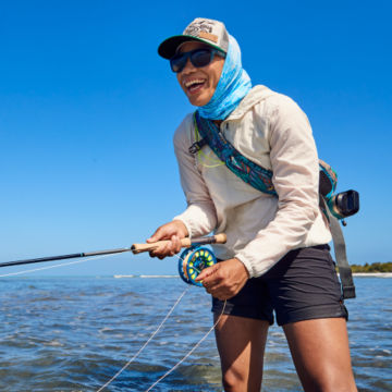 Woamn wading out in Women’s Jackson Quick-Dry Natural Fit Convertible 8½" Shorts with her fishing kit.