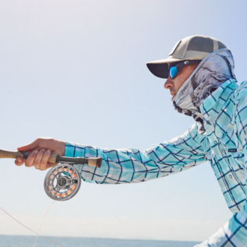 Angler in the Caribbean casts his Orvis rod with a prominent silver Hydros reel.