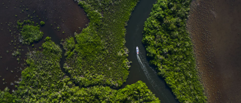 Drone photography of boat navigating through narrow waterway