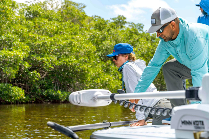 Benny showing Hannah something in the water while in a boat