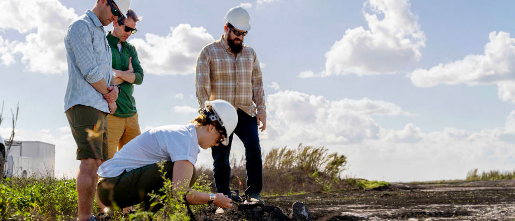 Four people investigating the soil in the Everglades