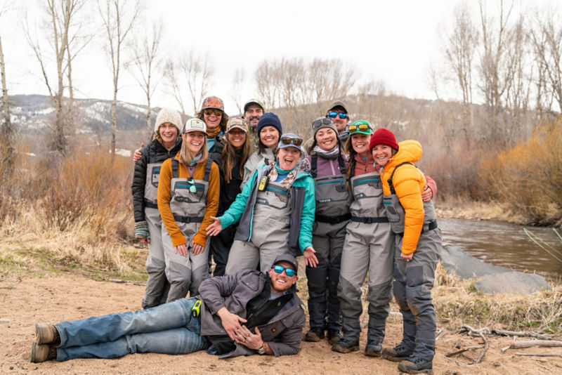 A group of people posing for the camera in fly fishing gear.