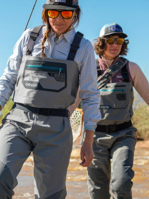 Women in Ultralight Convertible Waders walk down to the river.