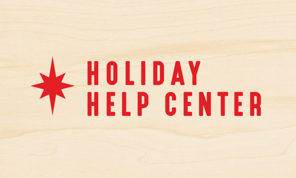 Holiday Help Center in red on a wood background.