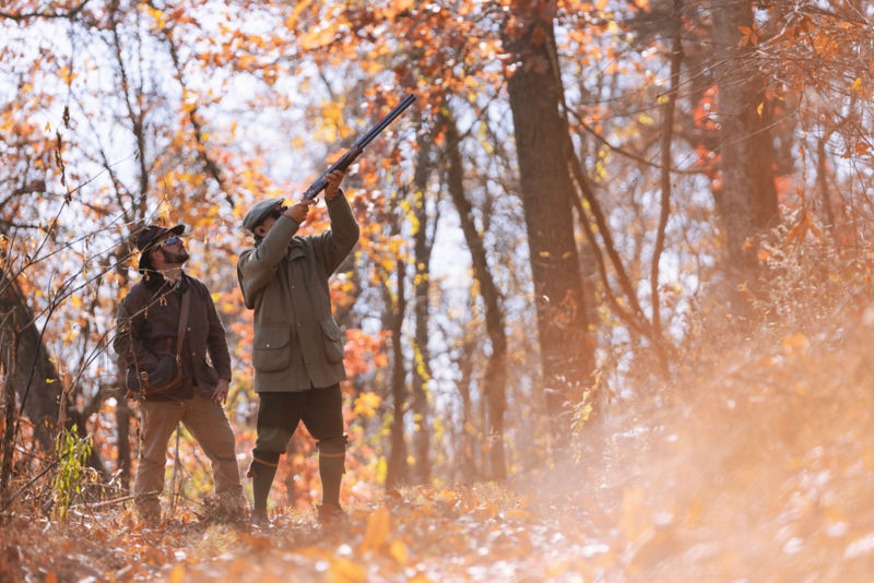 An instructor and student in the autumn woods hunting.