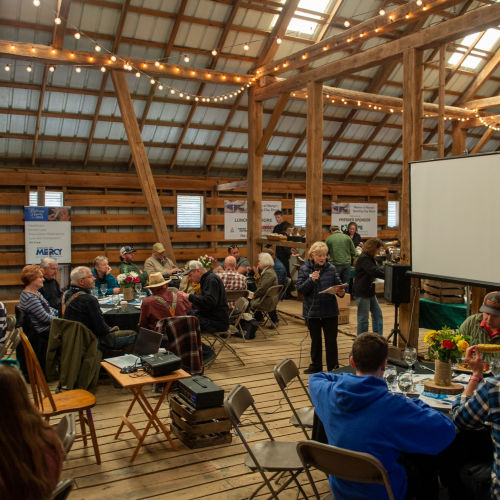 A group of people gathered inside a lodge for a corporate event