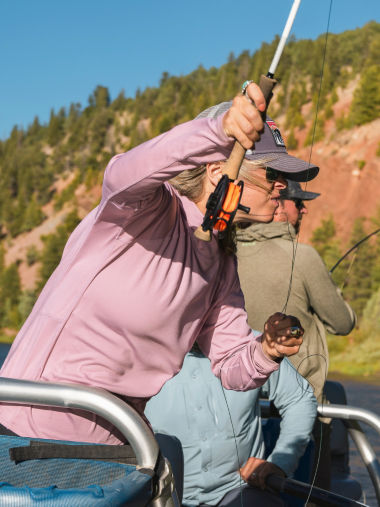 An angler in pink sun protection shirt focuses on her line.