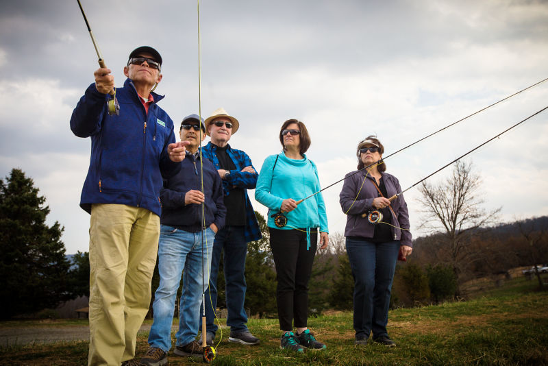 A fly-fishing instructor leads a group of people in a casting exercise at the Game Fair.
