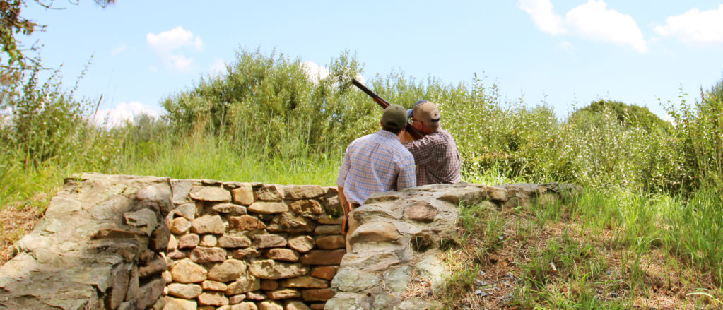 A student and an instructor in a stone wall practicing their shot