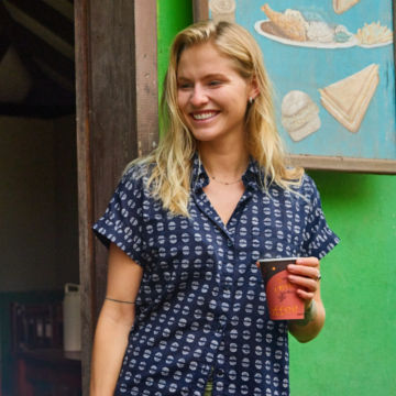 Woman in Easy Printed Camp Shirt holds a coffee.