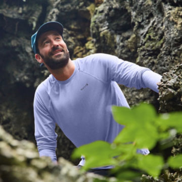 Man in DriCast shirt walks through a cave.