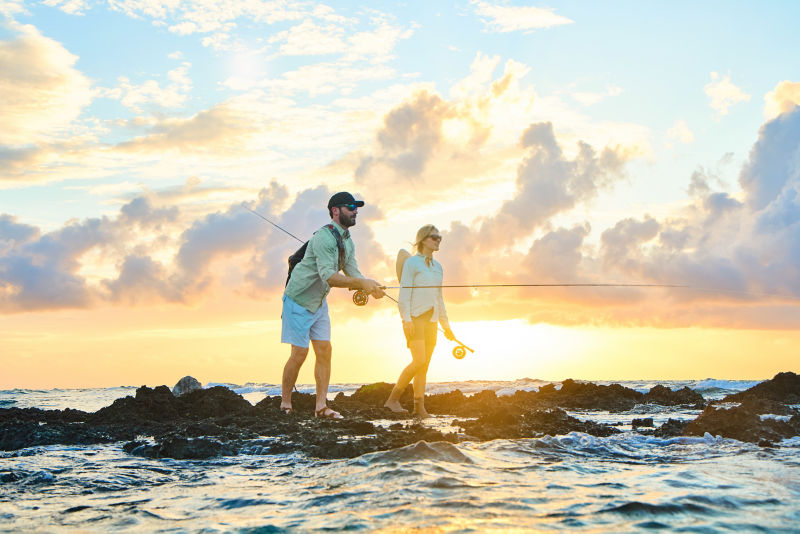 A pair of anglers casting into the ocean at sunrise.