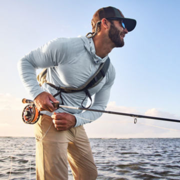 Man in Sun Protection Clothing casts fly rod.