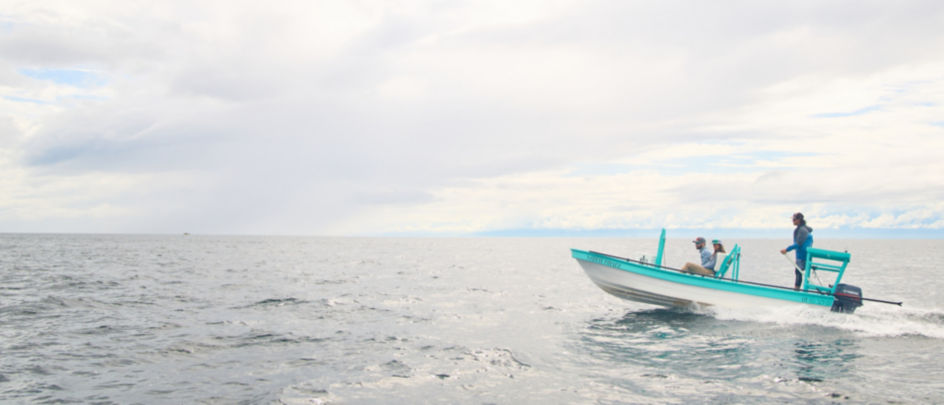 A fishing boat speeding through tropical waters.