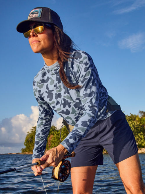 An Angler in a Sun Defense Shirt Casts in the shallows.