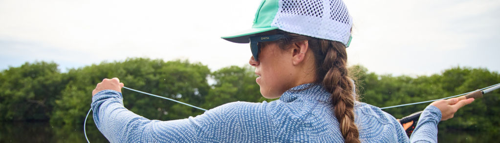 An angler wearing UPF clothing, hat, and sunglasses.