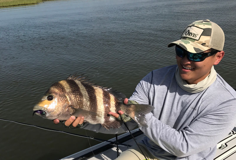 Ian smiles while holding up a fresh-caught fish.