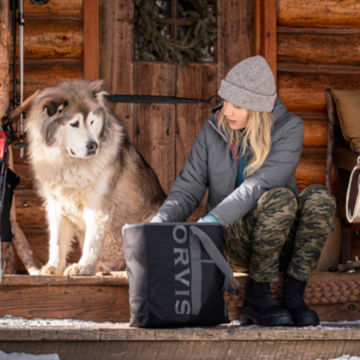 An owner and her dog look through her Orvis Nylon Tote Bag.