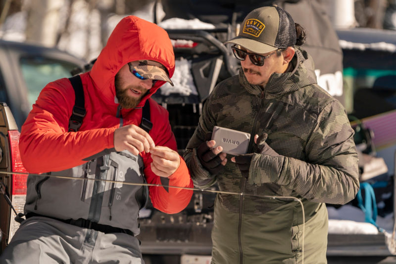 Two men pick flies on a cold day.